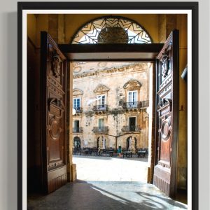 muru muru aria siciliana ambientato 02 Uno scorcio pieno di luce e fascino senza tempo: le porte aperte del Duomo di Siracusa incorniciano la piazza inondata dal sole, con i suoi palazzi barocchi all'interno di una cornice nera