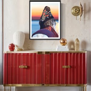 muru muru bellas tramonto ambientata stampa di Una figura elegante e misteriosa cavalca verso l’orizzonte, avvolta in un mantello nero ricamato con un motivo a fiori, in una cornice nera sopra uno mobile vintage