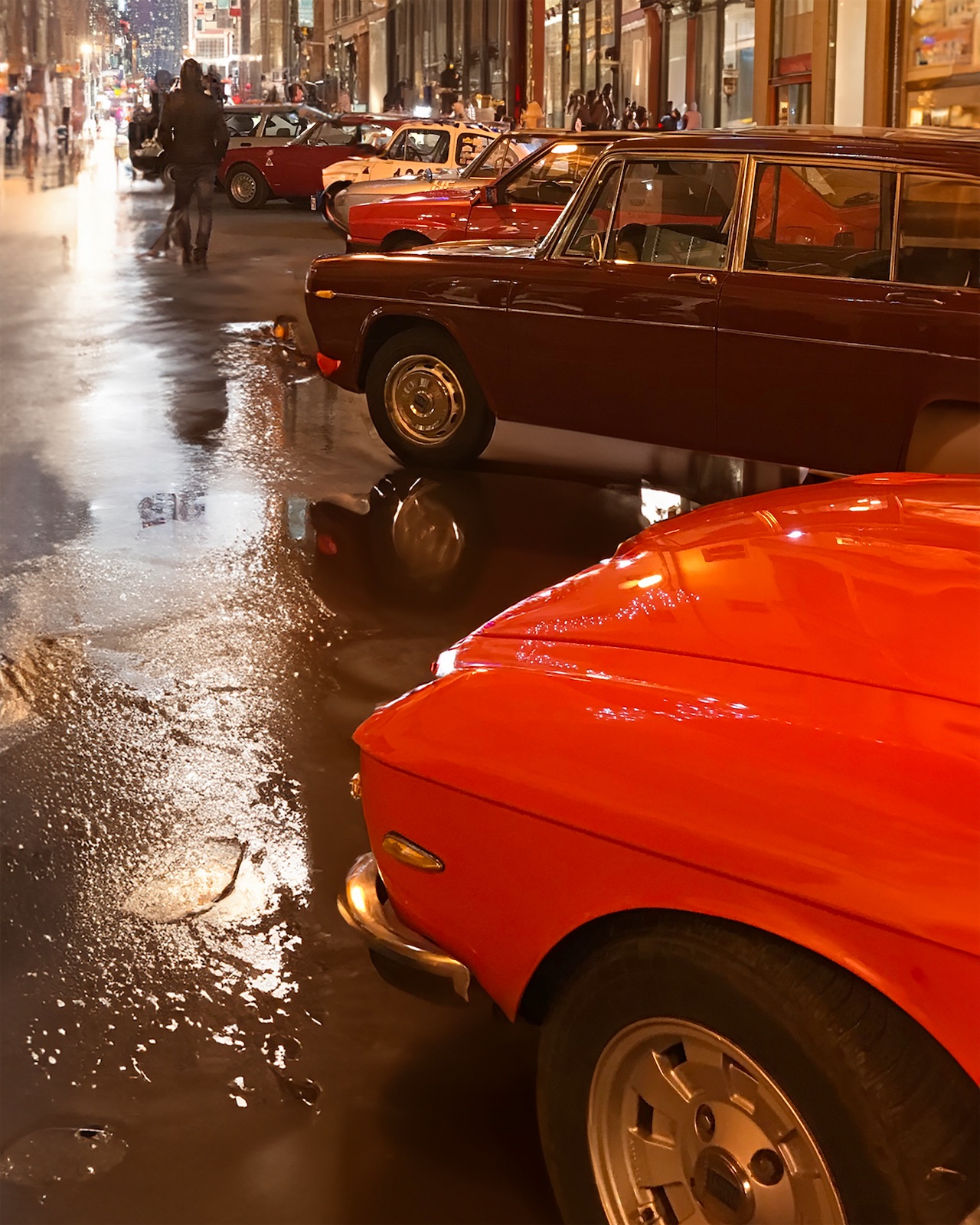 un raduno di auto d'epoca in una città con strade bagnate dalla pioggia