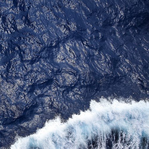 onde viste dall'alto di un traghetto si infrangono sull'azzurro del mare mediterraneo